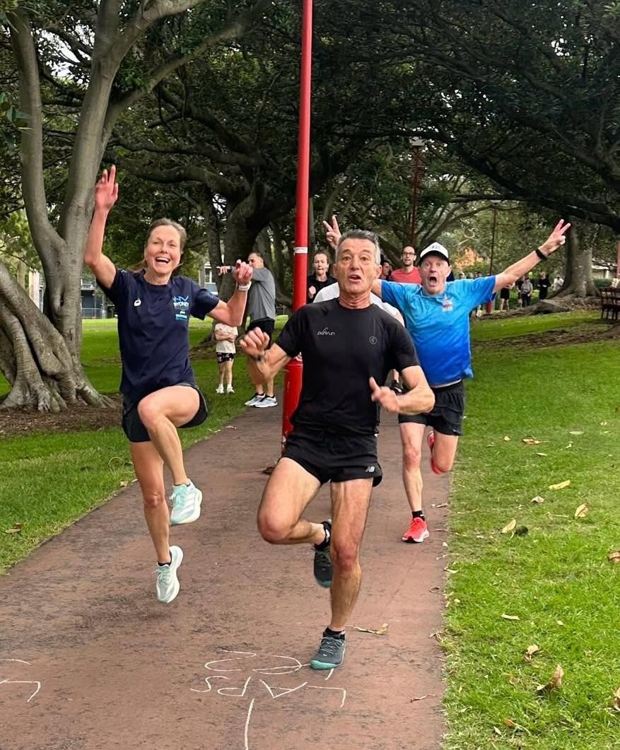 A joyful group running together on a Sydney park path